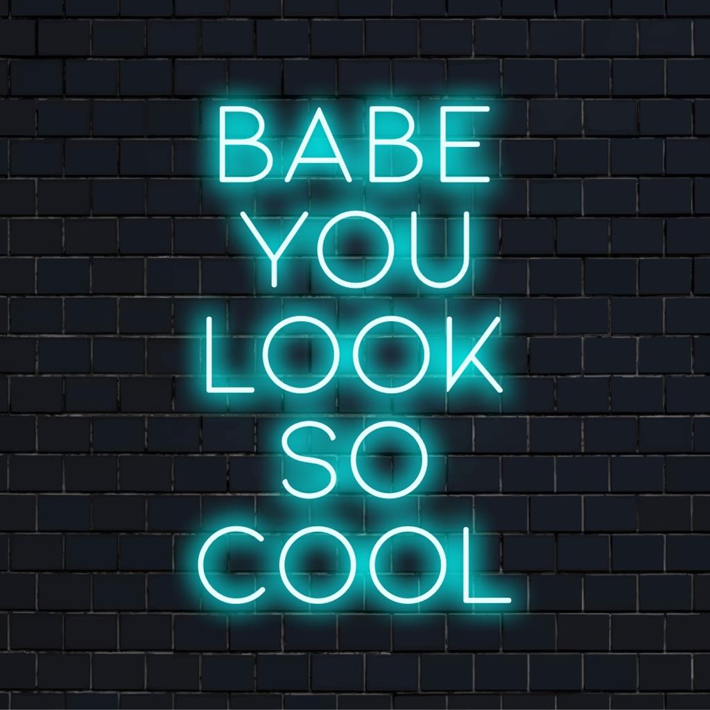 Bright neon sign displaying Babe You Look So Cool; combines neon quote art with graphic design for a unique decor statement.