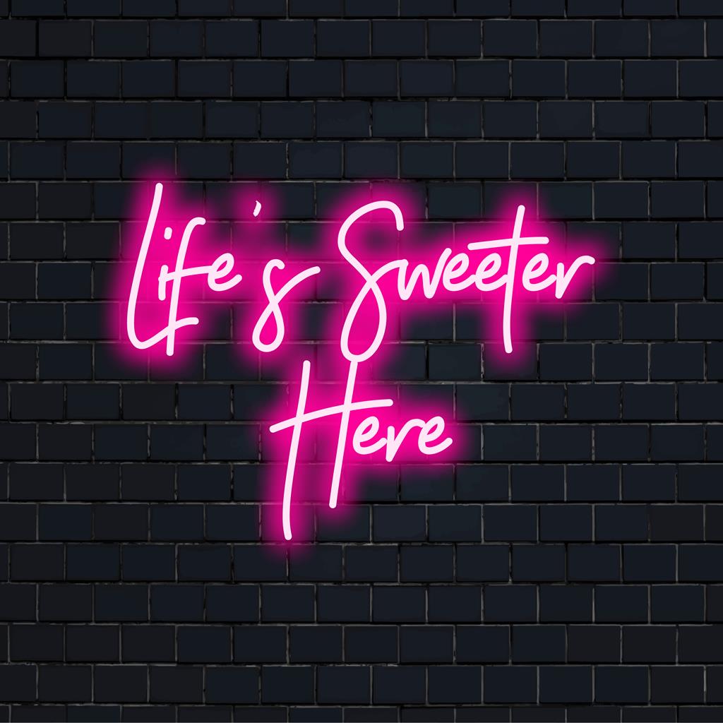 Vibrant LED neon sign displaying Life's Sweeter Here, perfect for enhancing any space with custom neon light charm.