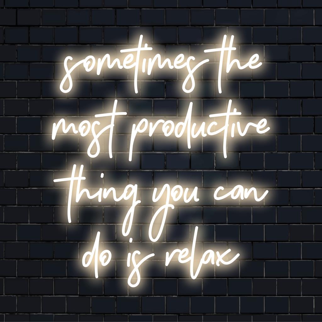 Vlastní LED neonový nápis v uklidňující modré barvě s nápisem Někdy nejproduktivnější věcí, kterou můžete udělat, je relaxovat.