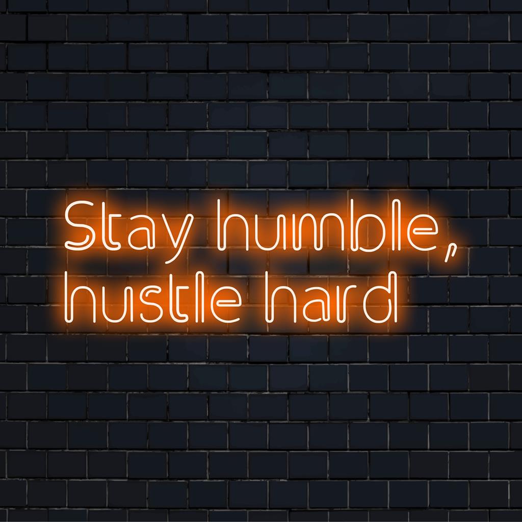Insegna LED personalizzata con la scritta "Stay Humble, Hustle Hard"; perfetto mix di ispirazione artistica e atmosfera chic con decorazioni al neon.