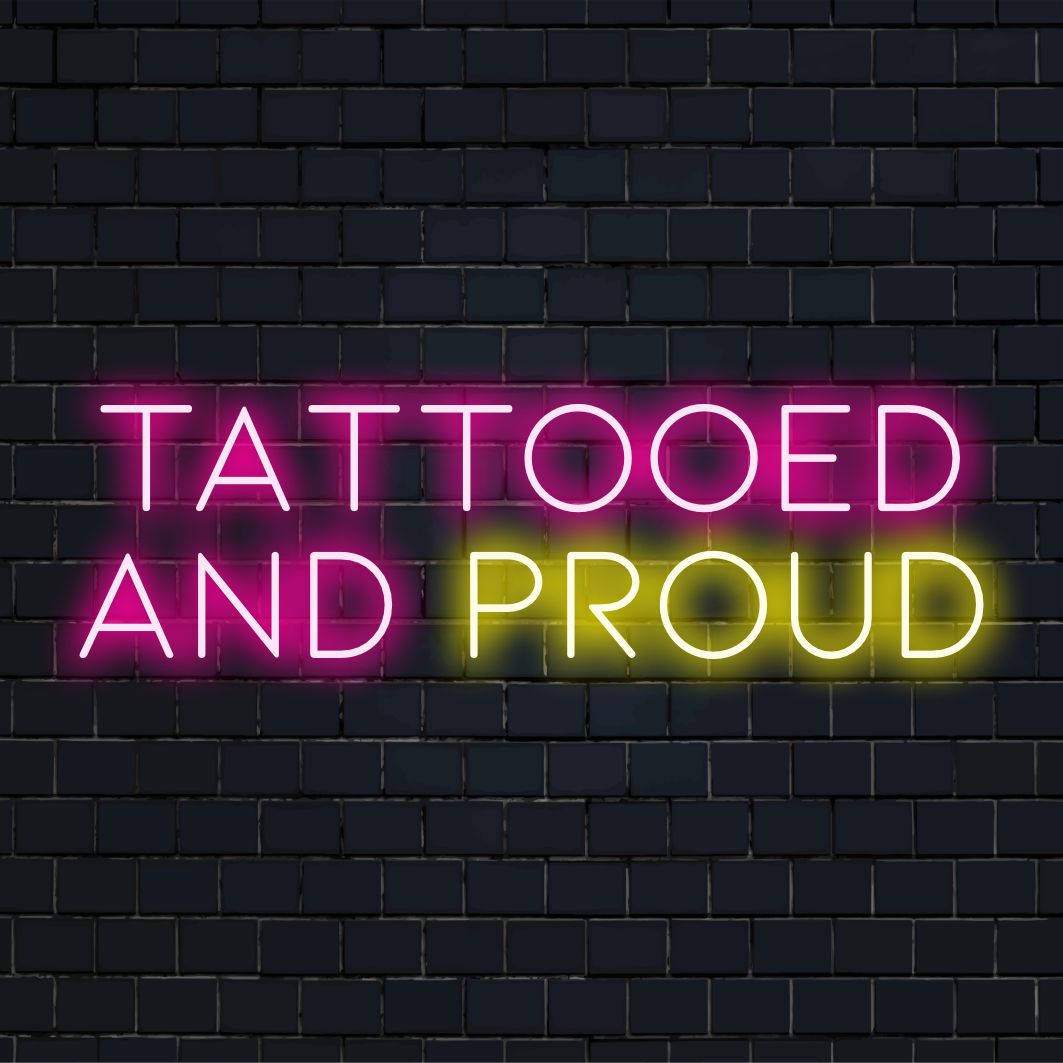 LED neon sign reading Tattooed And Proud; vibrant handmade design with personalized neon art flair.