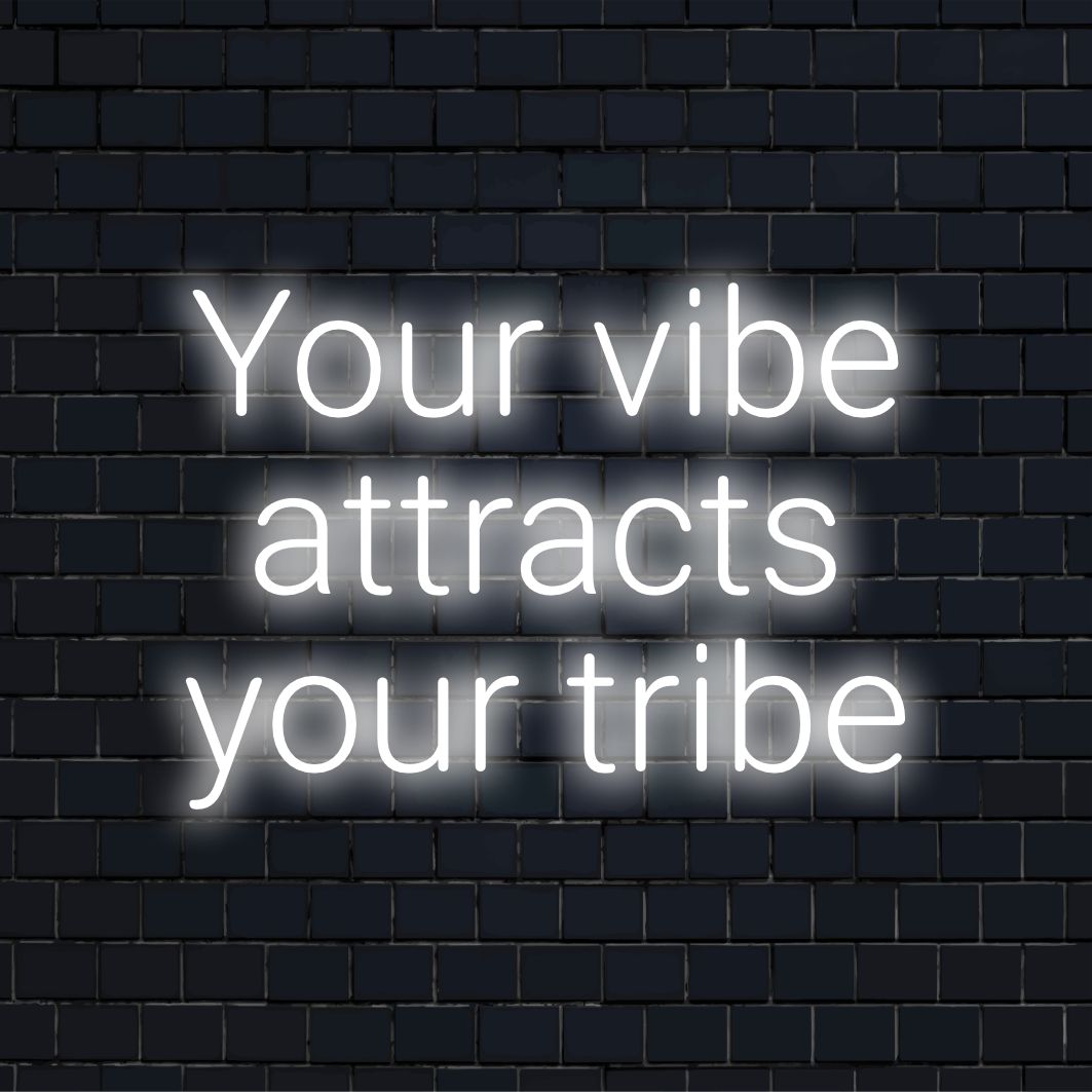 Vivace insegna al neon con la scritta Your Vibe Attracts Your Tribe, realizzata con eleganti lettere LED, perfetta per decorazioni murali e decorazioni moderne.