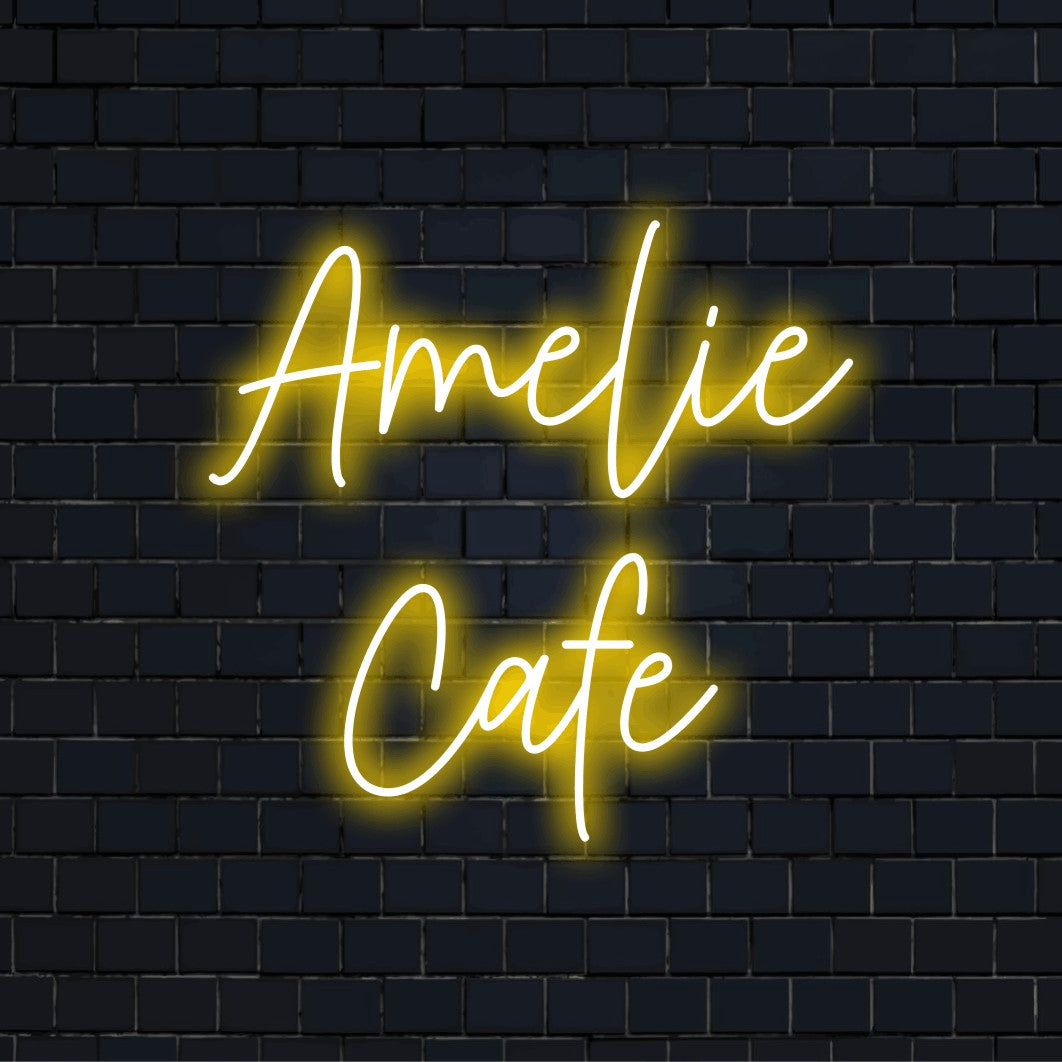 Amelie Cafe Personalized Neon Light with soft neon glow against black brick wall