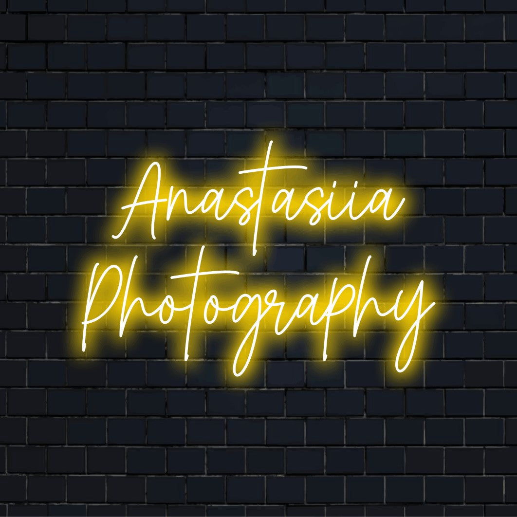 Anastasiia Photography Custom Name Neon Sign, bright neon lettering against black brick wall