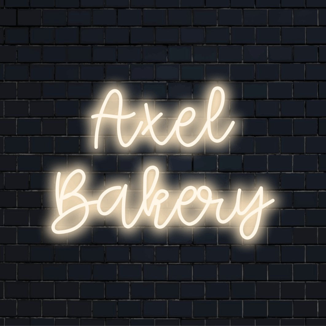 Axel Bakery Custom Name Neon Sign, neon text light against brick backdrop