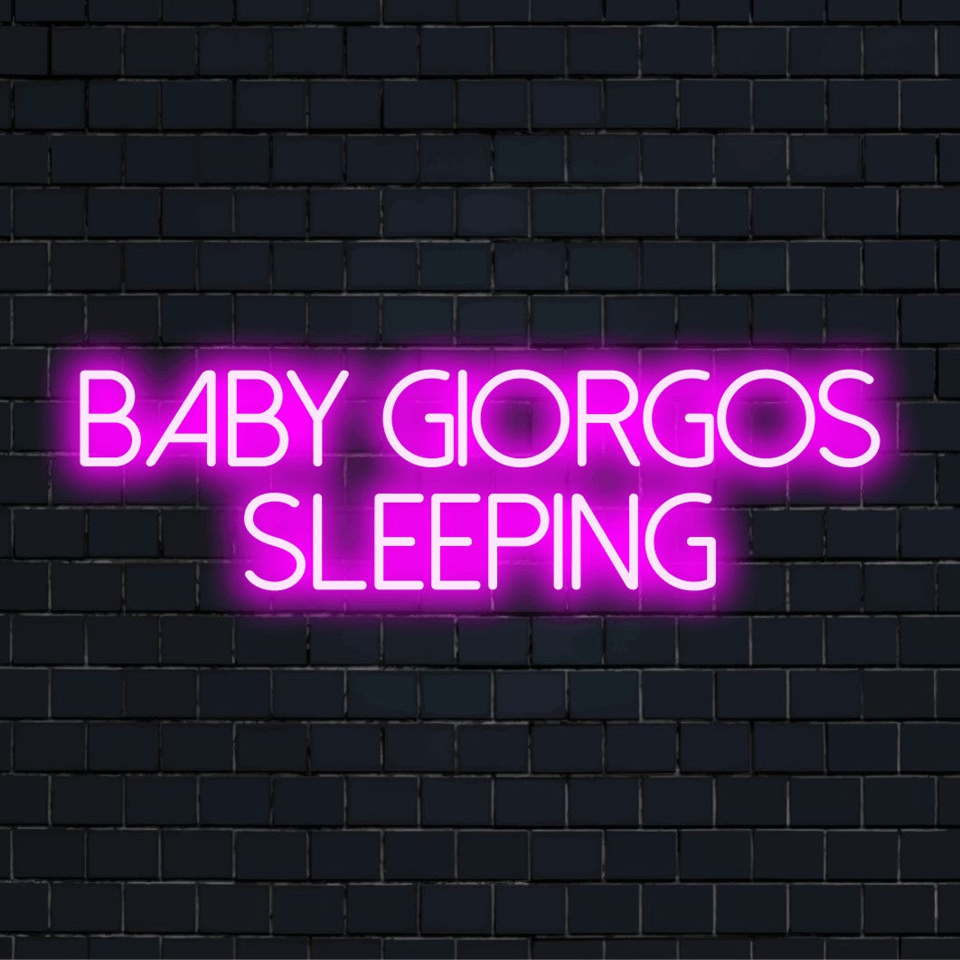Baby Giorgos Sleeping Personalized Neon Light with glowing neon text against brick backdrop
