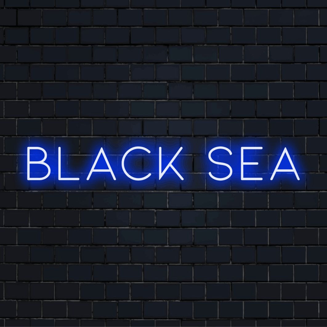 Black Sea LED Neon Sign, glowing lettering on black brick background