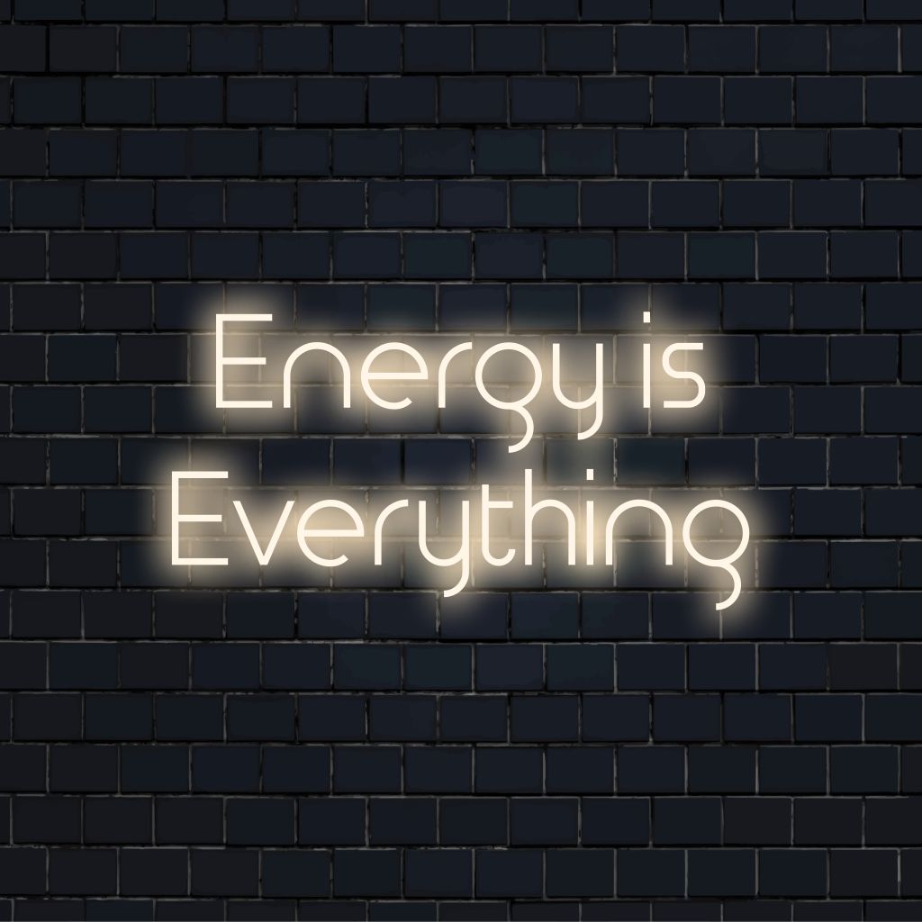 Energy Is Everything Neon Sign, neon text light against black brick wall