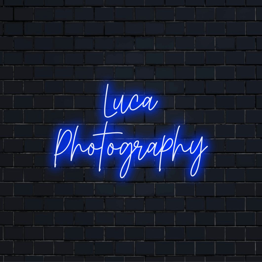 Luca Photography Custom Name Neon Sign, bright LED glow against black brick wall