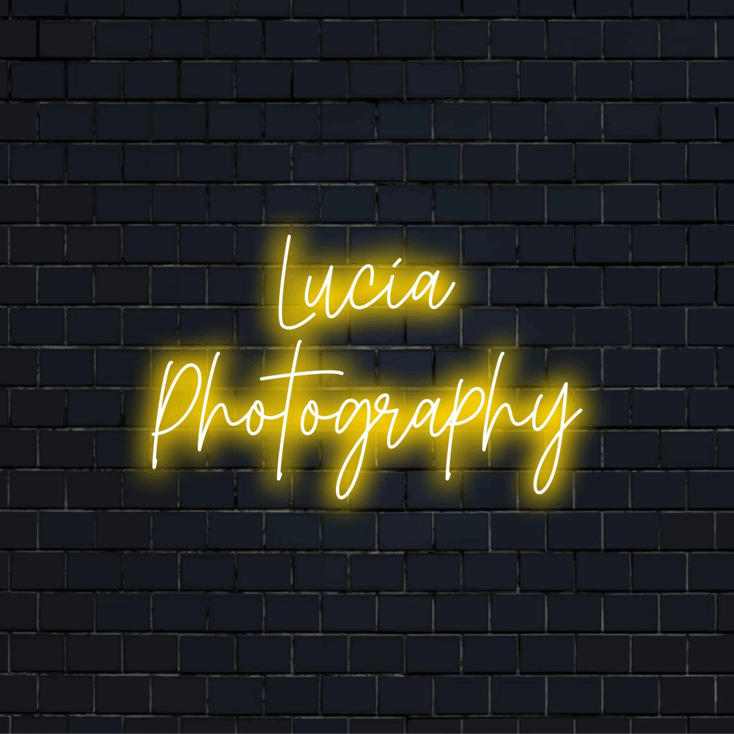 Lucia Photography Custom Name Neon Sign, soft neon glow on dark brick background
