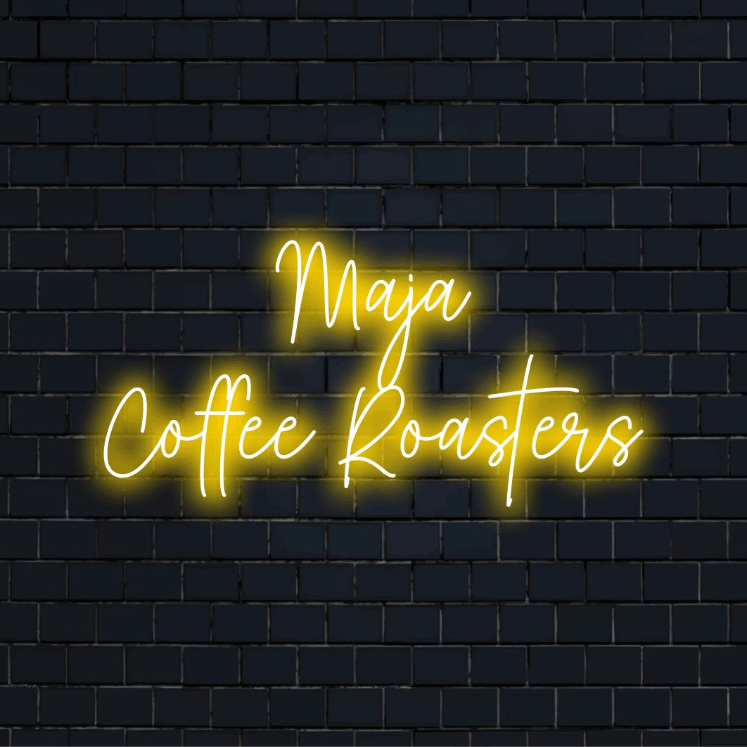 Maja Coffee Roasters Personalized Neon Light with glowing wall decor against black brick wall