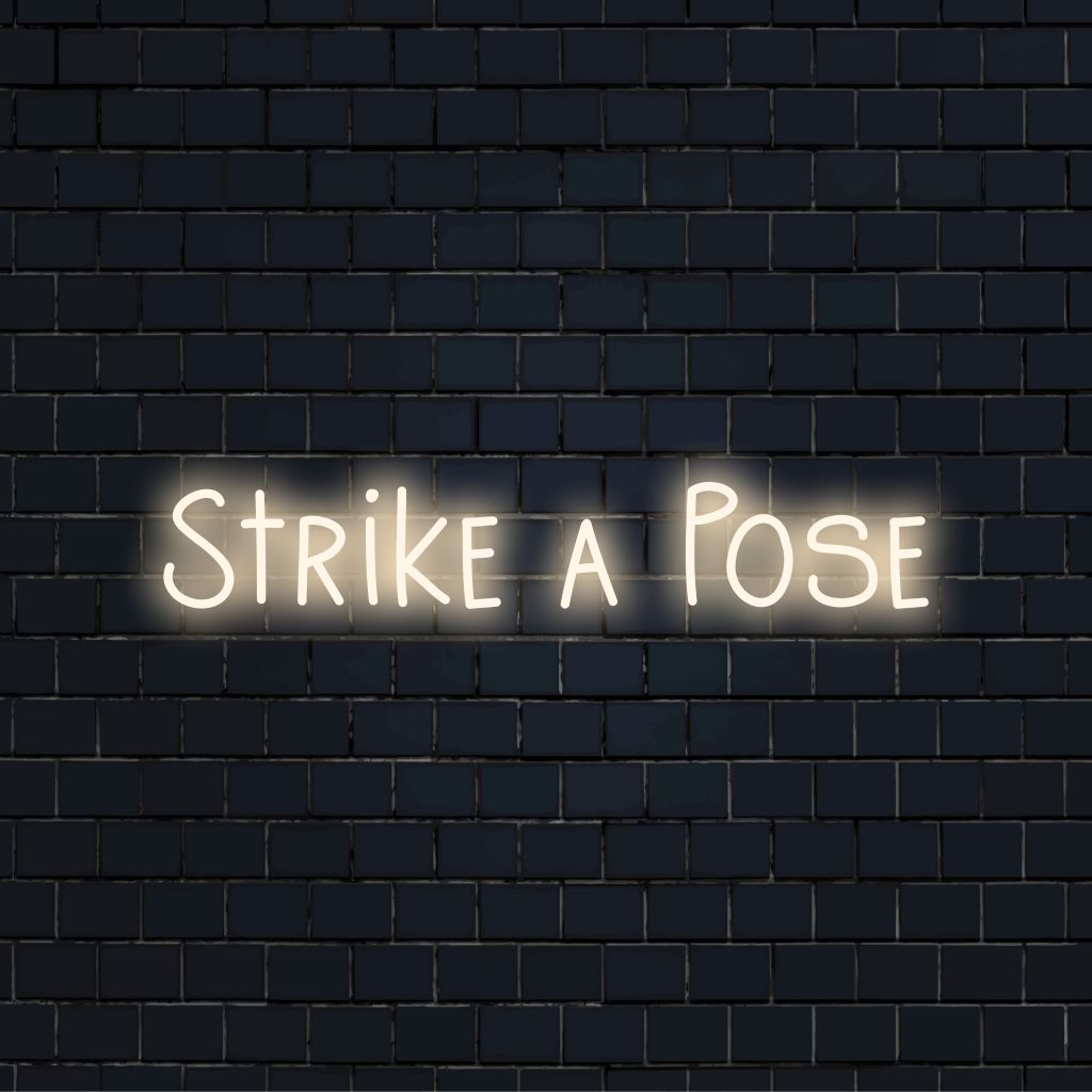 Strike A Pose Neon Sign, bright LED glow on dark brick background