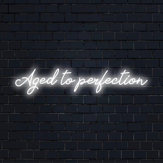 LED neon sign displaying Aged To Perfection in stylish script, ideal for adding a personalized touch to any space.