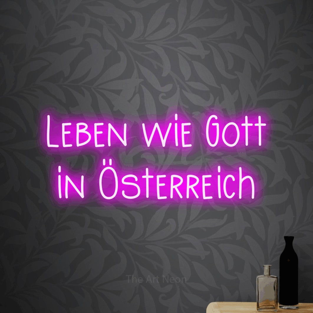 LED neon sign reading “Leben wie Gott in Österreich”, arranged in 2 lines.