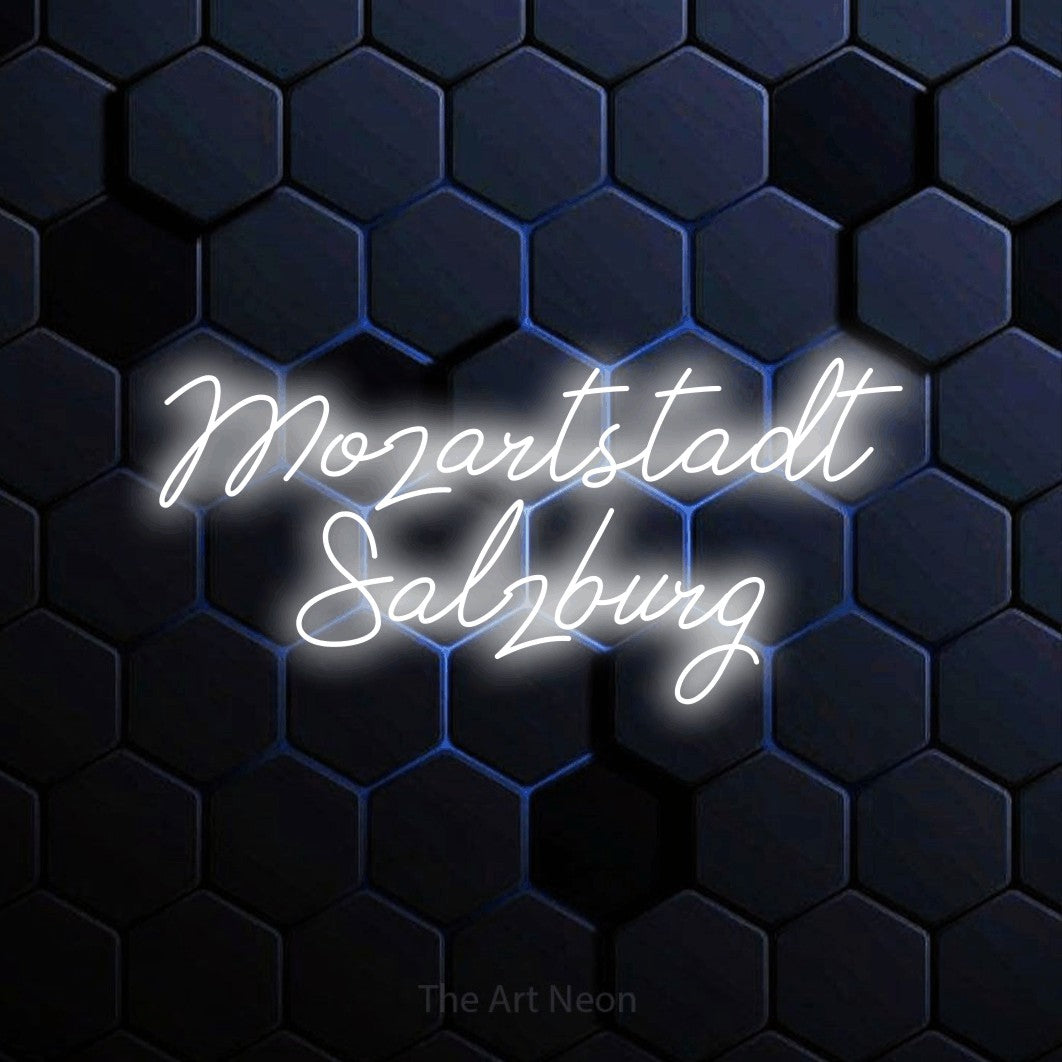 LED neon sign reading “Mozartstadt Salzburg”, arranged in 2 lines.