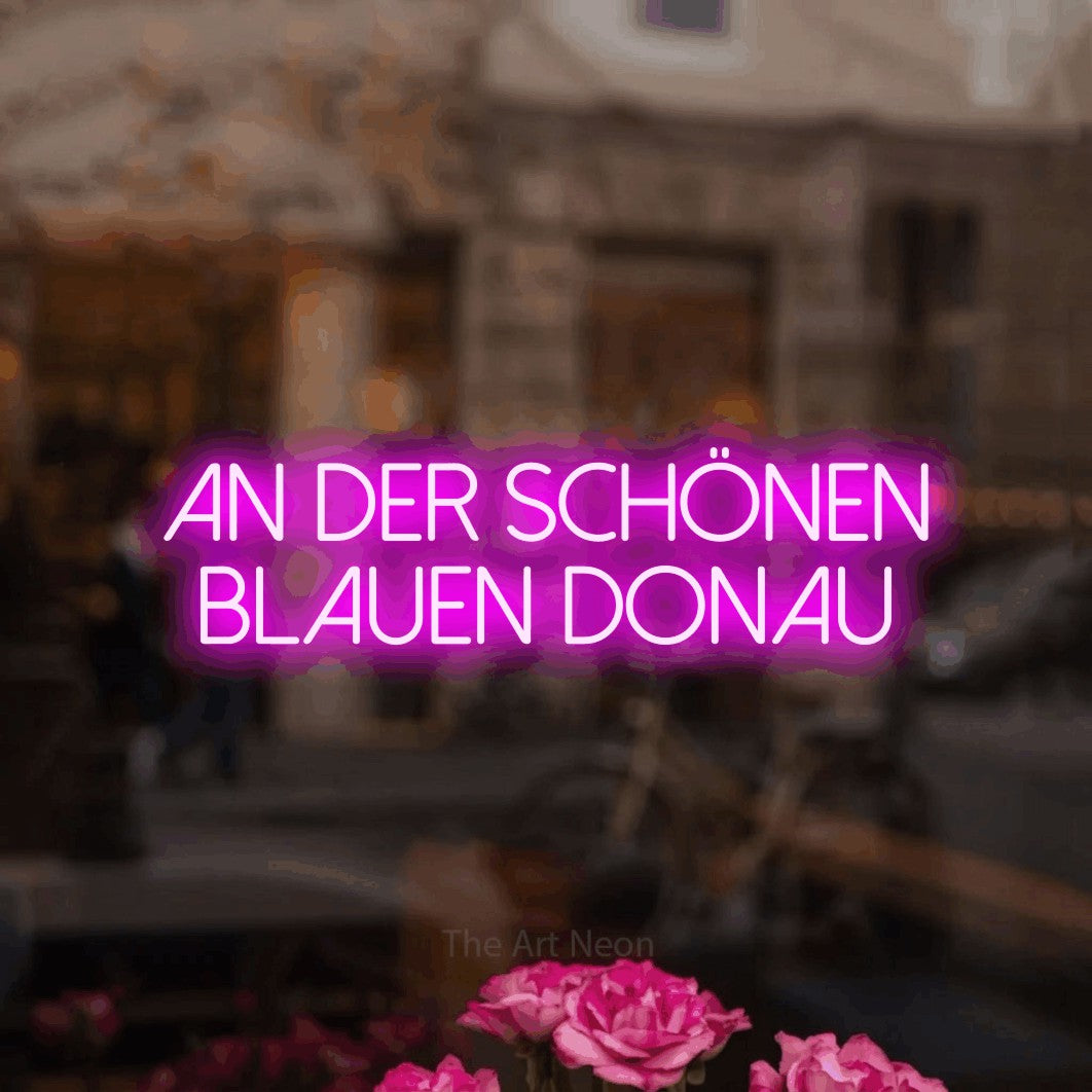 LED neon sign reading “An der SCHÖNEN blauen Donau”, arranged in 2 lines.