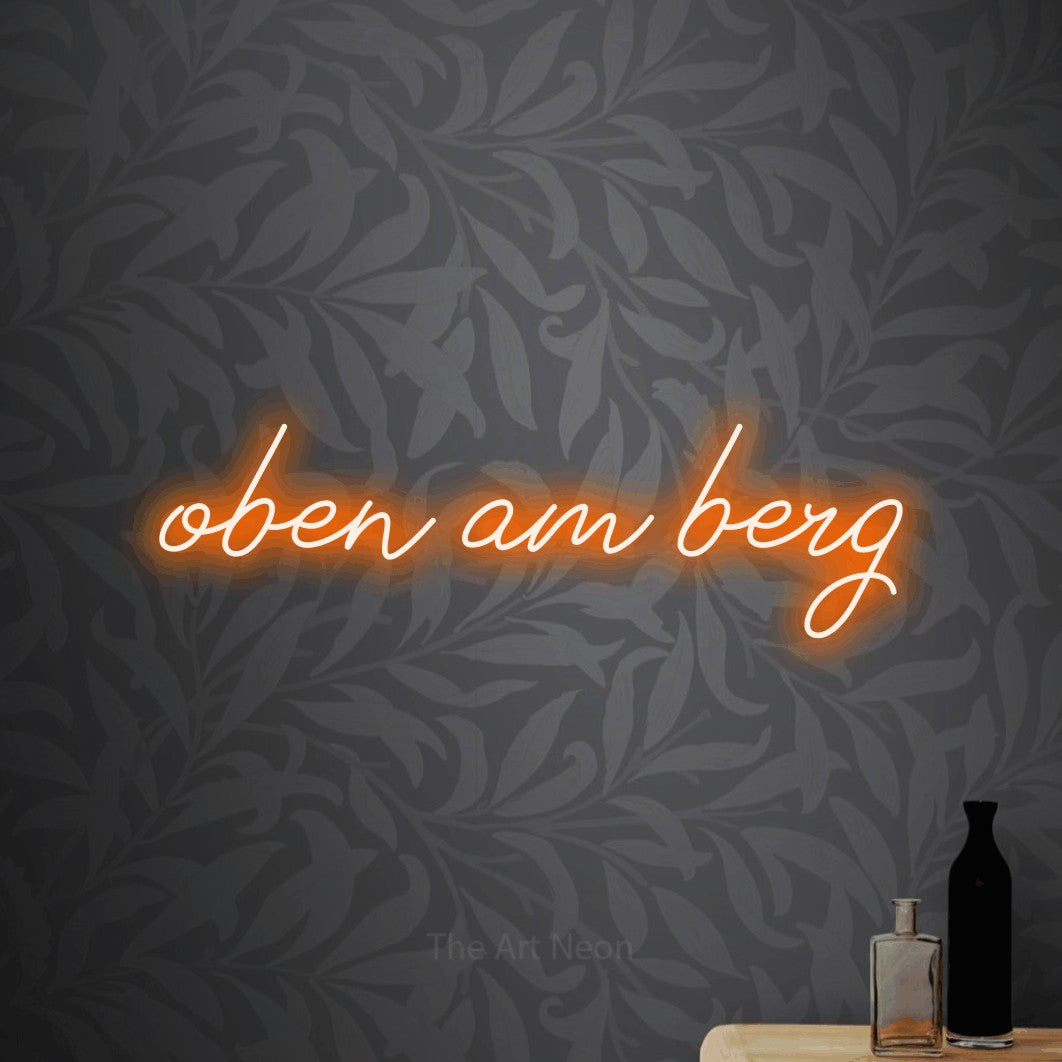LED neon sign reading “oben am berg”, arranged in a single line.