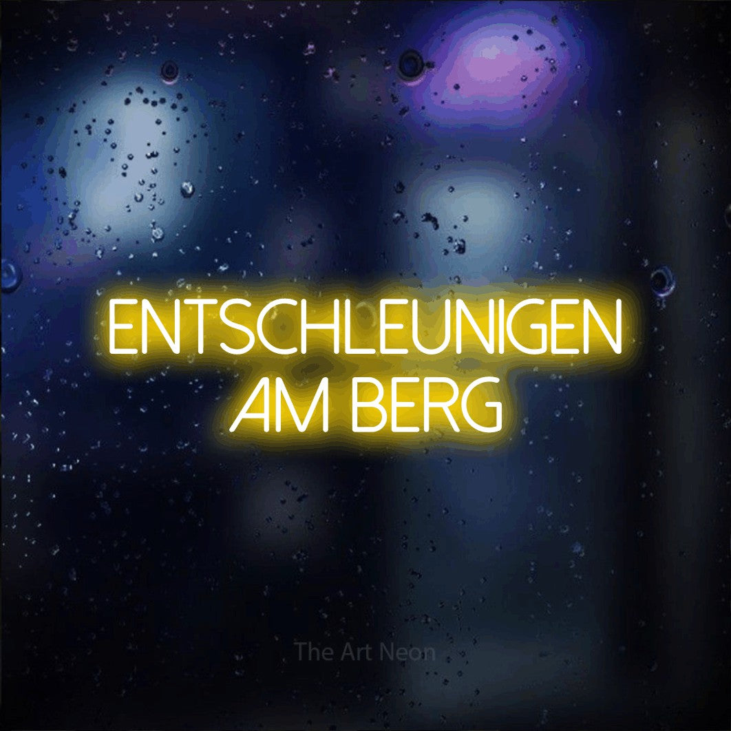 LED neon sign reading “Entschleunigen am Berg”, arranged in 2 lines.
