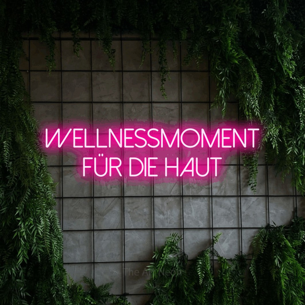 LED neon sign reading “WELLNESSMOMENT FÜR DIE HAUT”, arranged in 2 lines.