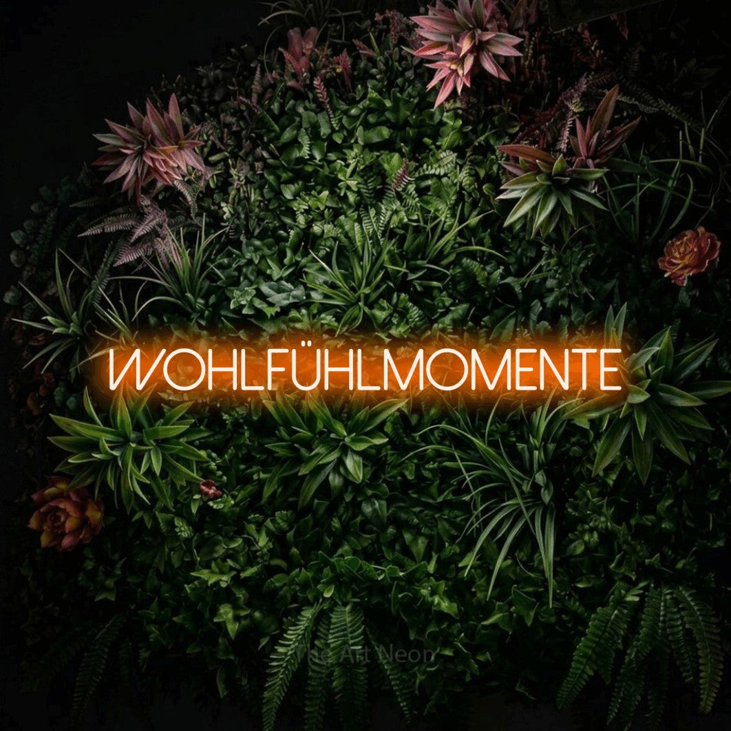 LED neon sign reading “wohlfühlmomente”, arranged in a single line.