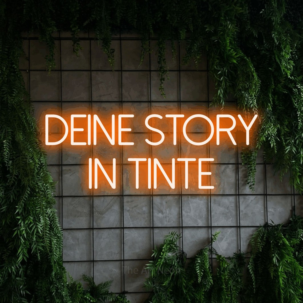 LED neon sign reading “DEINE STORY IN TINTE”, arranged in 2 lines.