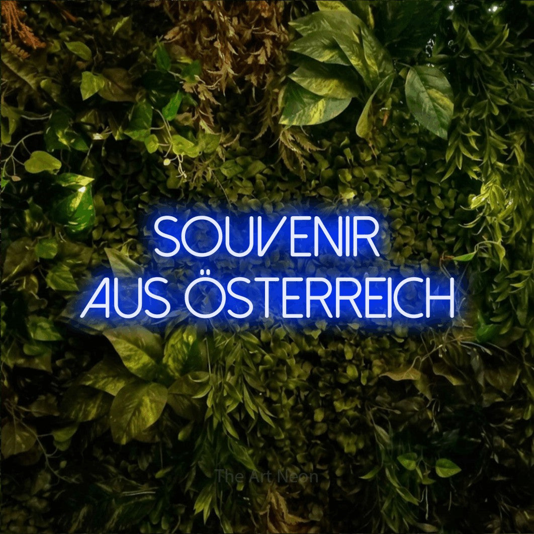LED neon sign reading “Souvenir aus Österreich”, arranged in 2 lines.