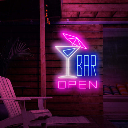The photo shows a neon sign with a cocktail with an umbrella on the left and the text 'open bar' on the right. This neon sign is ideal for bars, both indoor and outdoor.