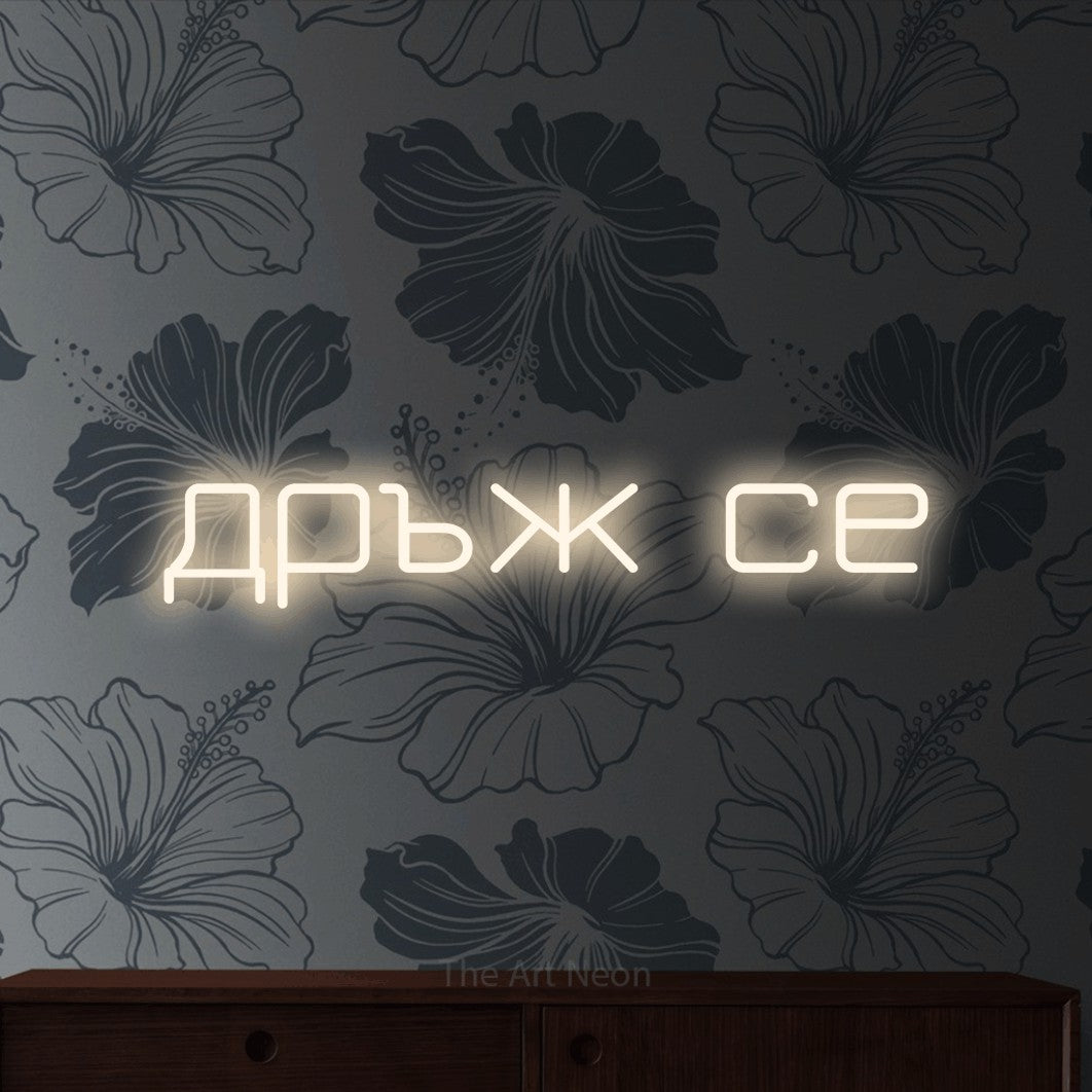 LED neon sign reading “дръж се”, arranged in a single line.