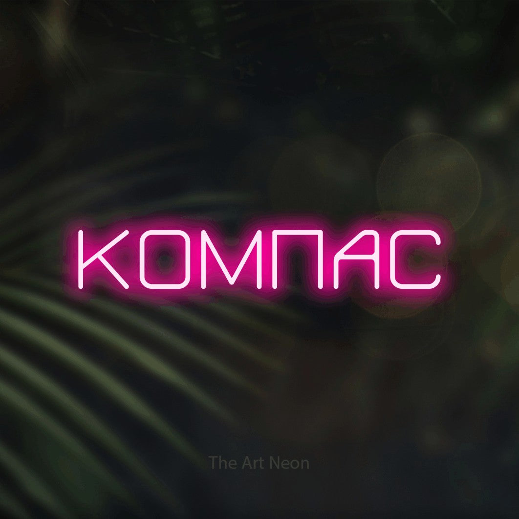 LED neon sign reading “КОМПАС”, arranged in a single line.