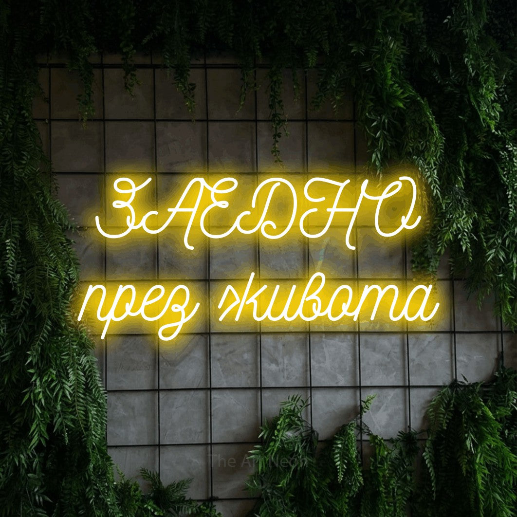 LED neon sign reading “ЗАЕДНО през живота”, arranged in two lines.