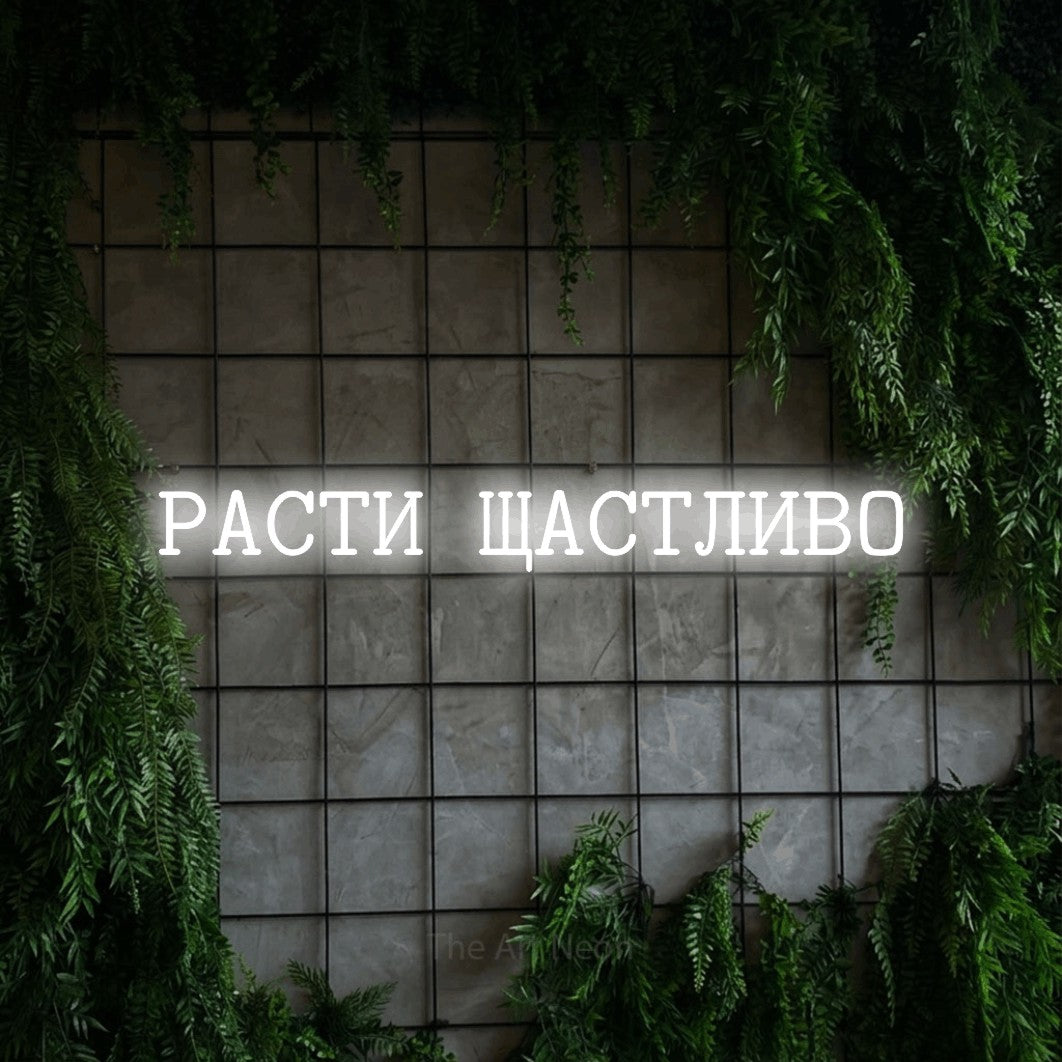 LED neon sign reading “РАСТИ ЩАСТЛИВО”, arranged in a single line.