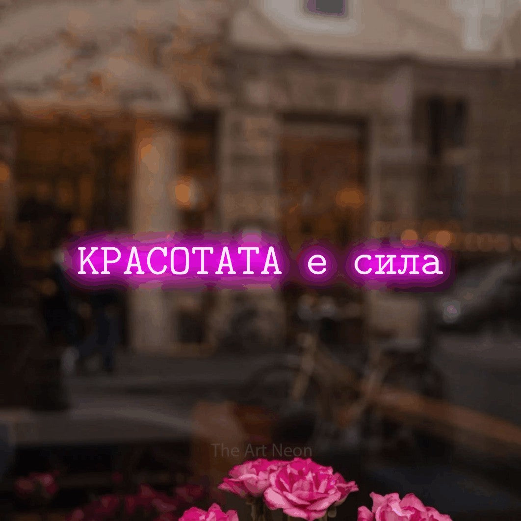 LED neon sign reading “КРАСОТАТА е сила”, arranged in a single line.