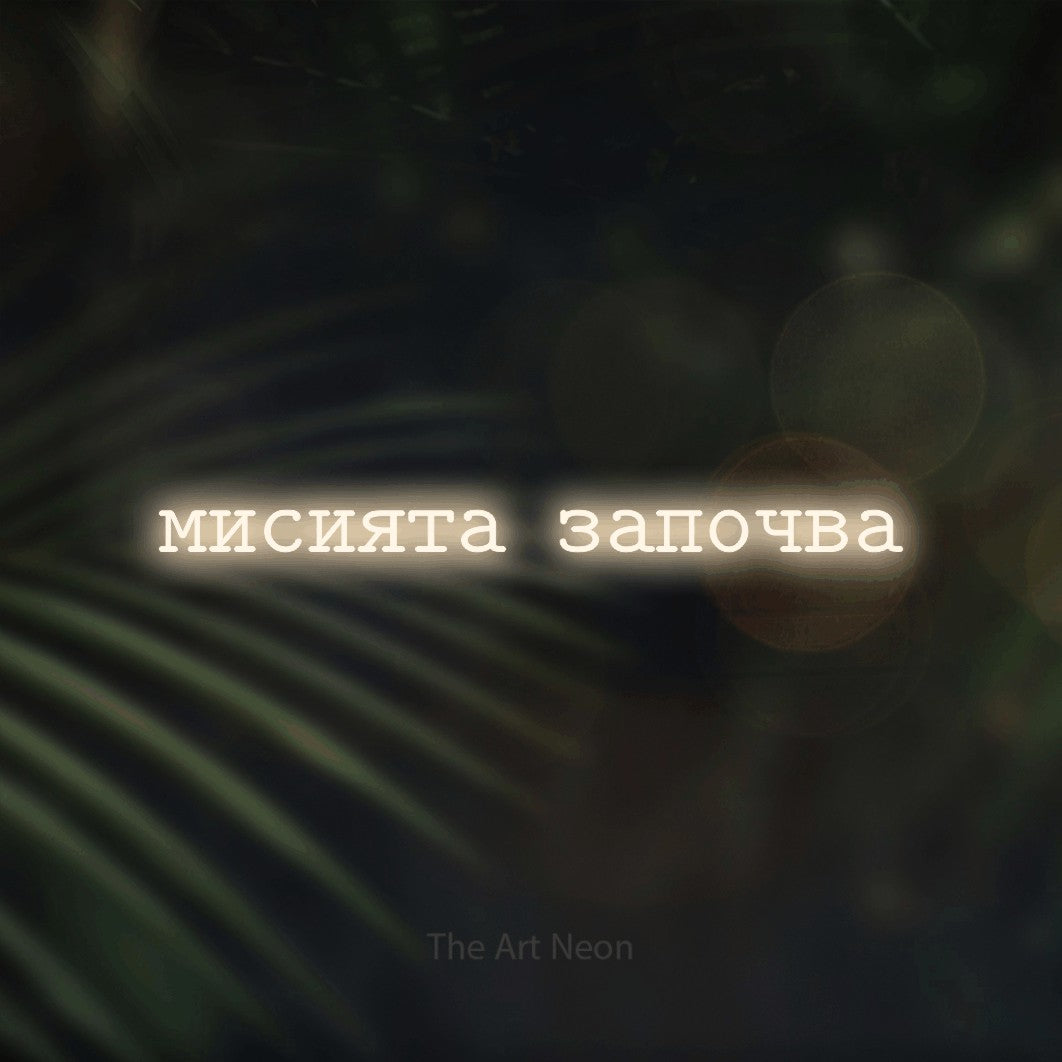 LED neon sign reading “мисията започва”, arranged in a single line.