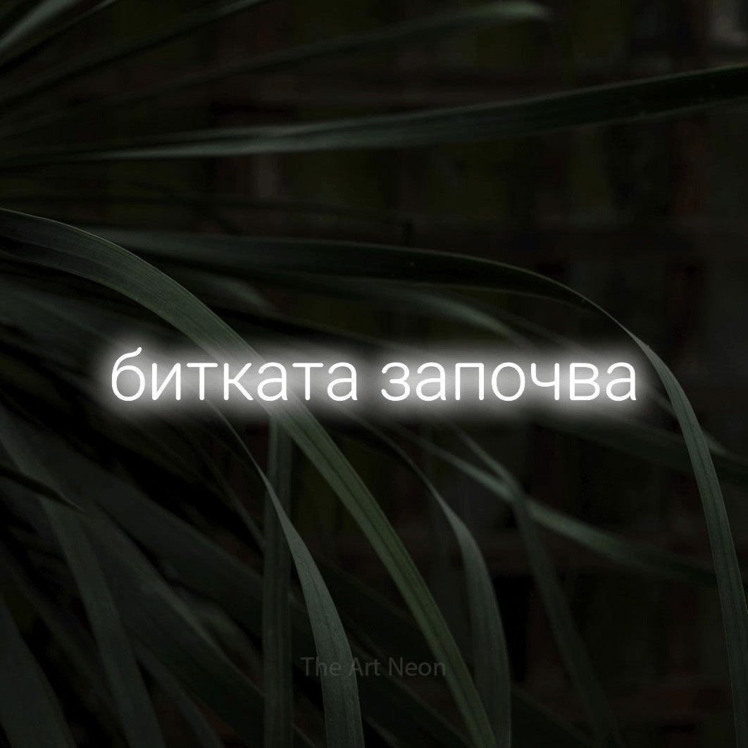 LED neon sign reading “битката започва”, arranged in a single line.