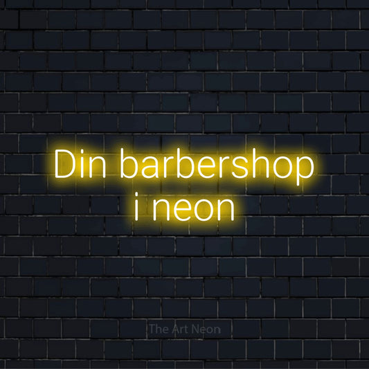 Personligt neonskilt med teksten “Din barbershop i neon” på en sort murstensvæg
