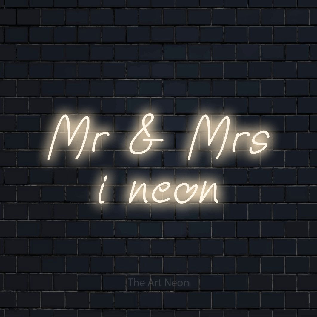 Personligt neonskilt med teksten “Mr & Mrs i neon” på en sort murstensvæg