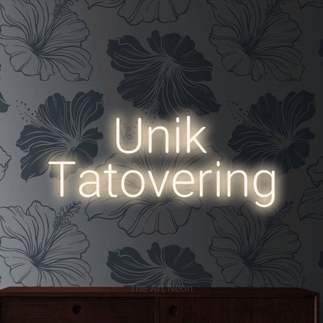 LED neon sign reading “Unik Tatovering”, arranged in 2 lines.