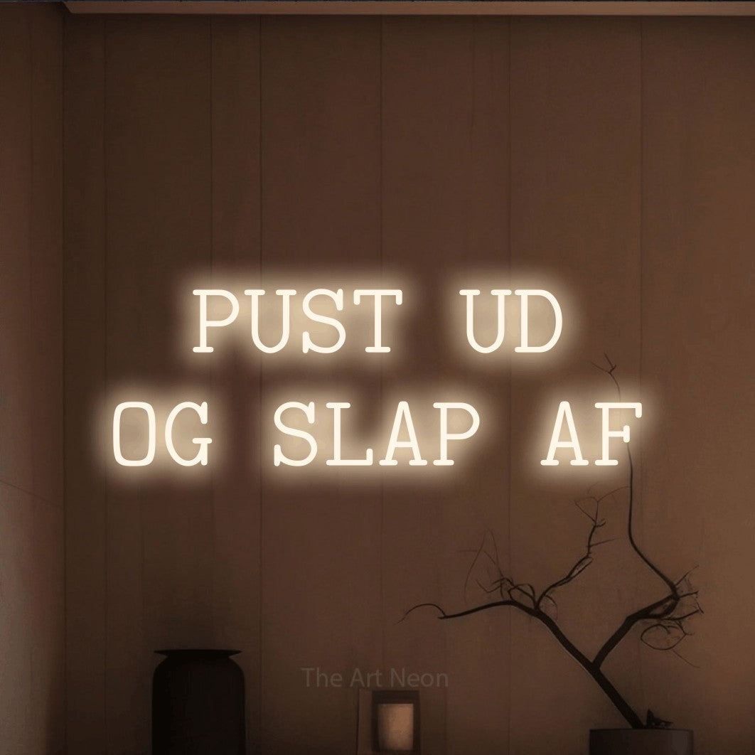 LED neon sign reading “PUST UD OG SLAP AF”, arranged in 2 lines.