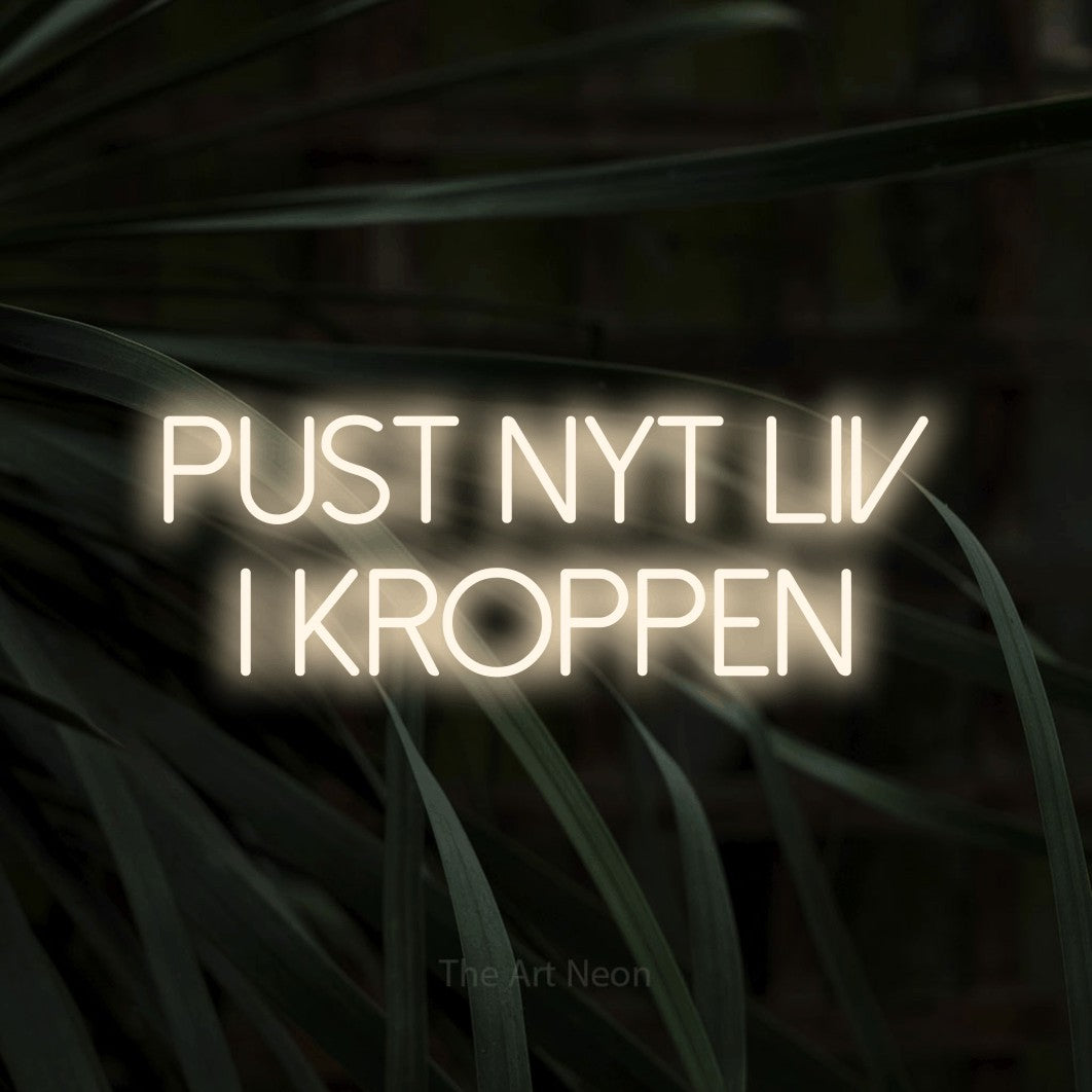 LED neon sign reading “PUST NYT LIV I KROPPEN”, arranged in 2 lines.