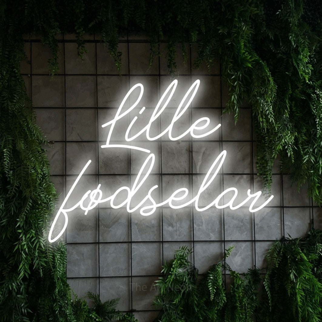 LED neon sign reading “Lille fødselar”, arranged in 2 lines.