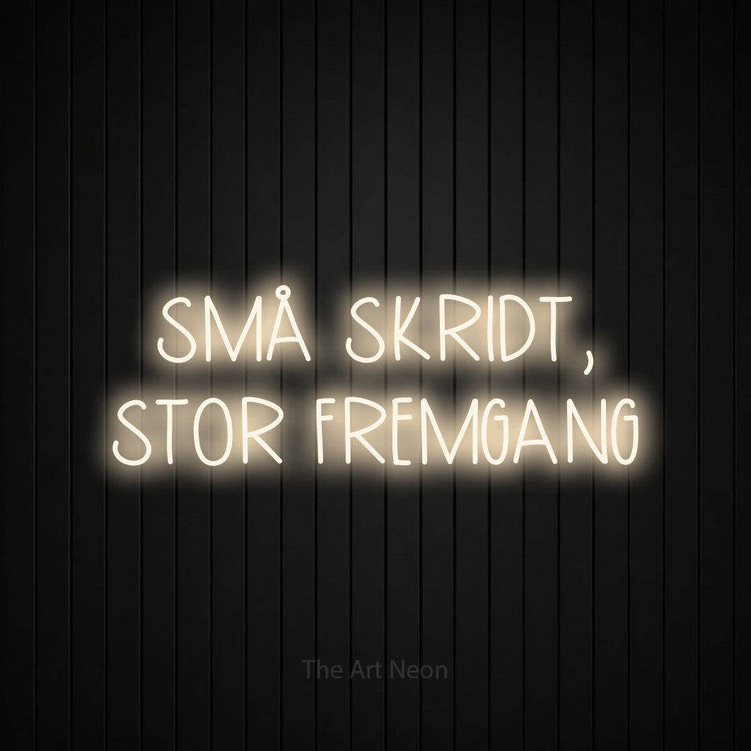 LED neon sign reading “SMÅ SKRIDT, STOR FREMGANG”, arranged in 2 lines.
