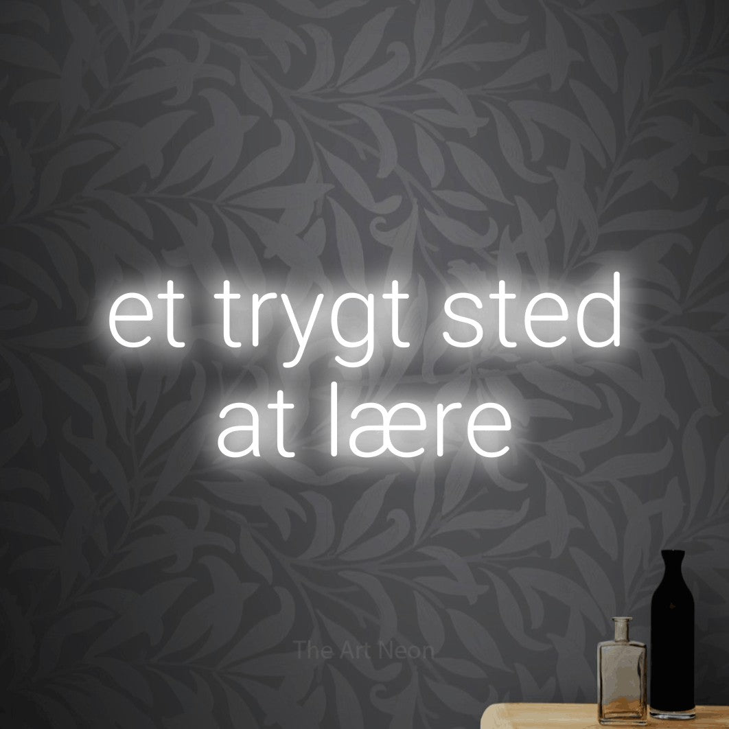 LED neon sign reading “et trygt sted at lære”, arranged in 2 lines.