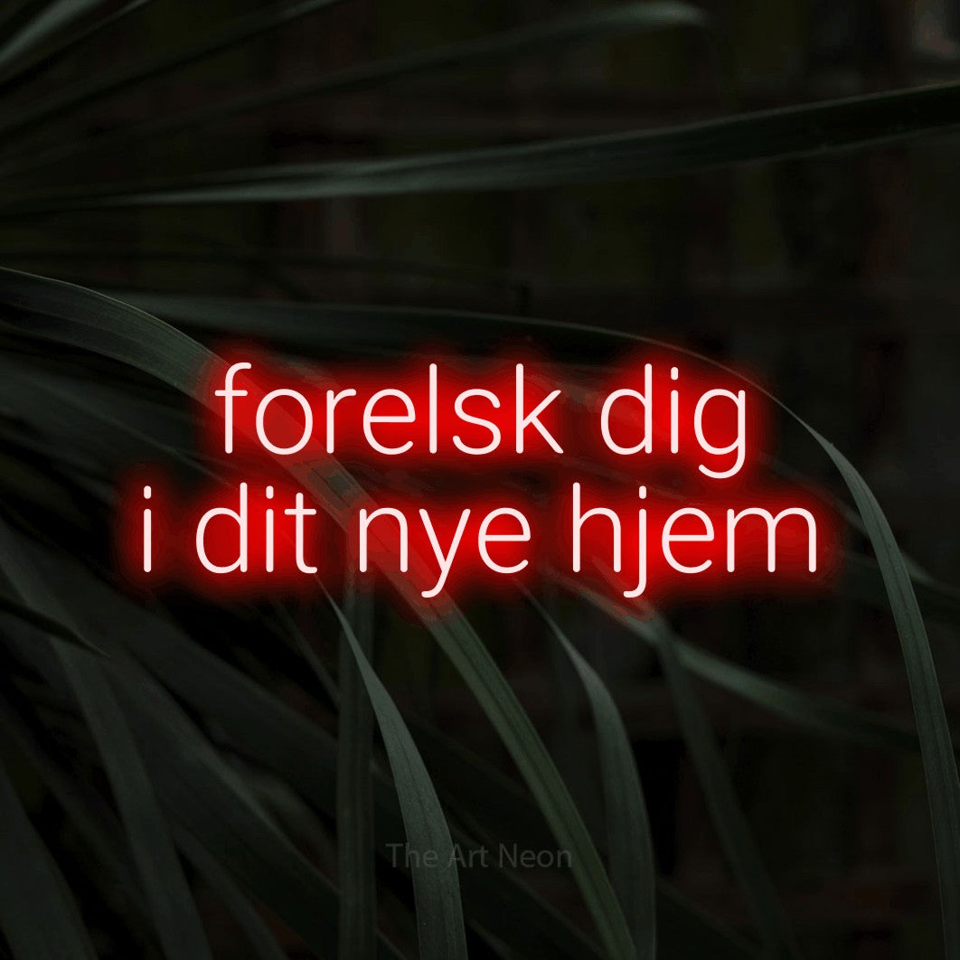 LED neon sign reading “forelsk dig i dit nye hjem”, arranged in 2 lines.
