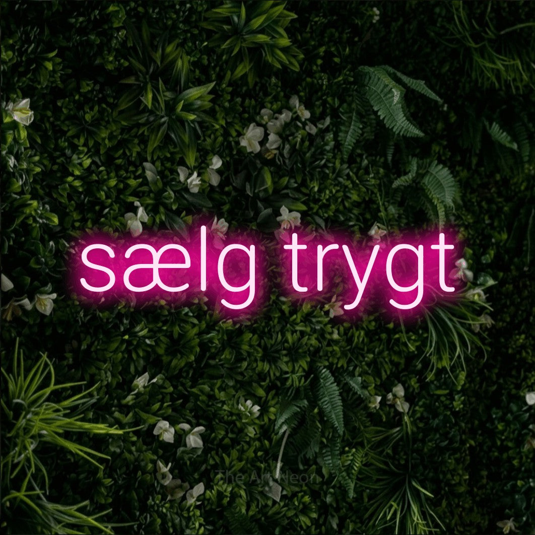 LED neon sign reading “sælg trygt”, arranged in a single line.