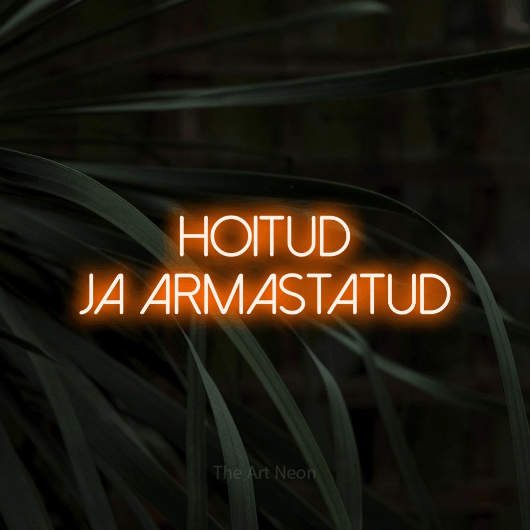 LED neon sign reading “Hoitud Ja Armastatud”, arranged in 2 lines.