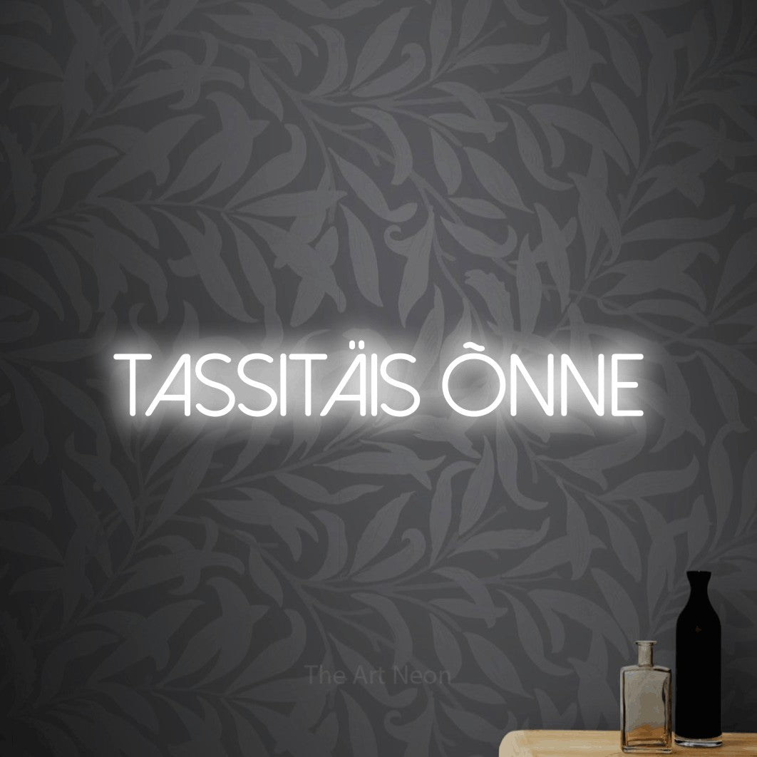 LED neon sign reading “tassitäis õnne”, arranged in a single line.