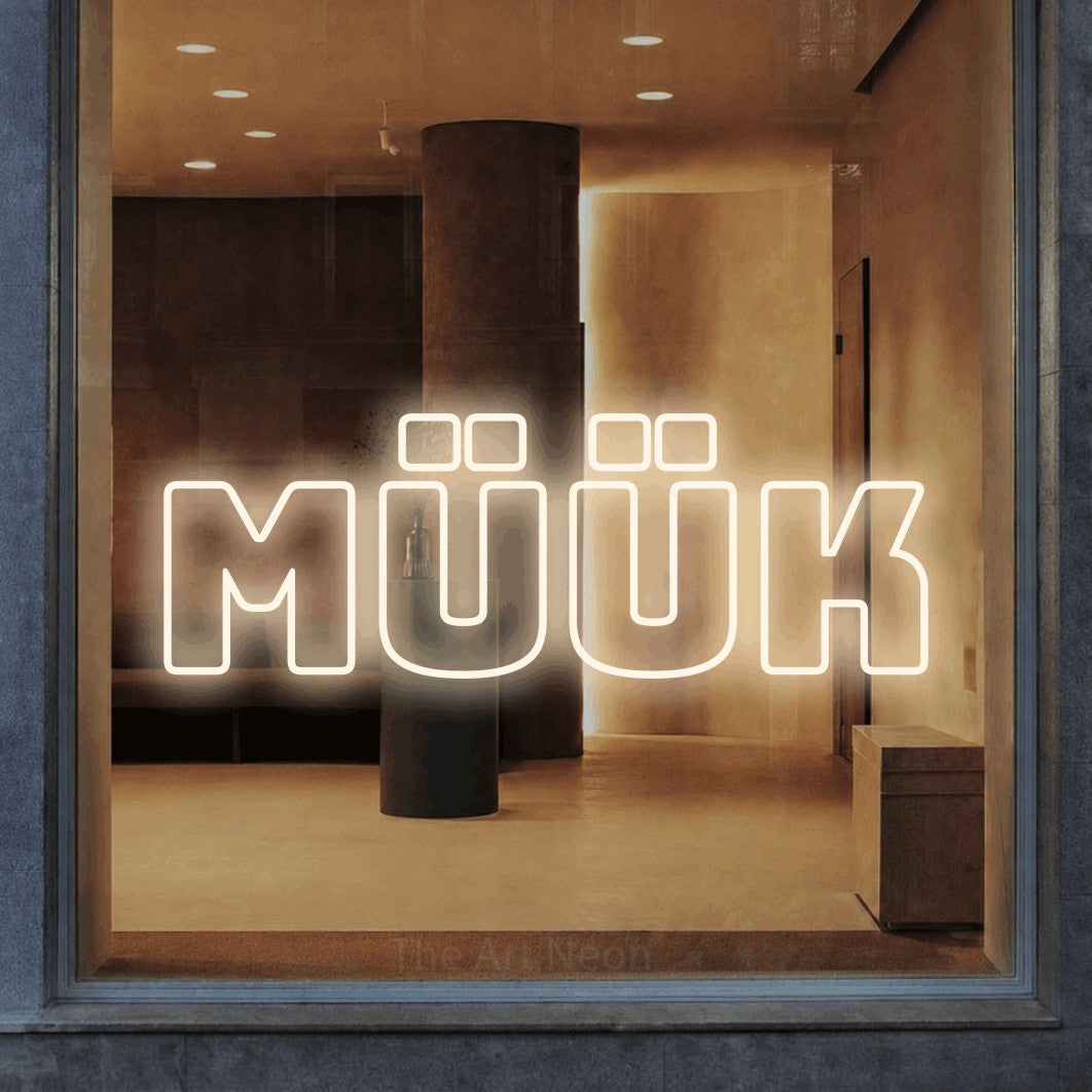 LED neon sign reading “MÜÜK”, arranged in a single line.