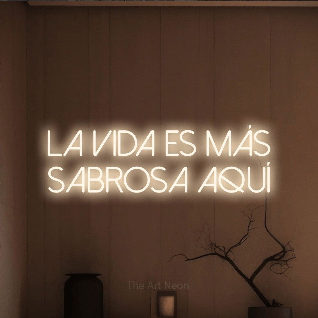 LED neon sign reading “la vida es más sabrosa aquí”, arranged in 2 lines.