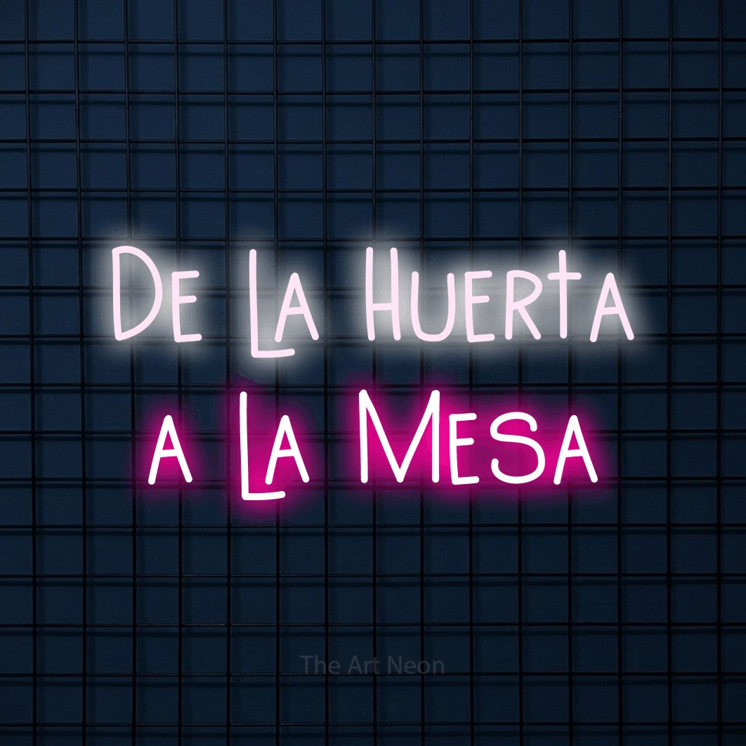 LED neon sign reading “De la Huerta a la Mesa”, arranged in 2 lines.