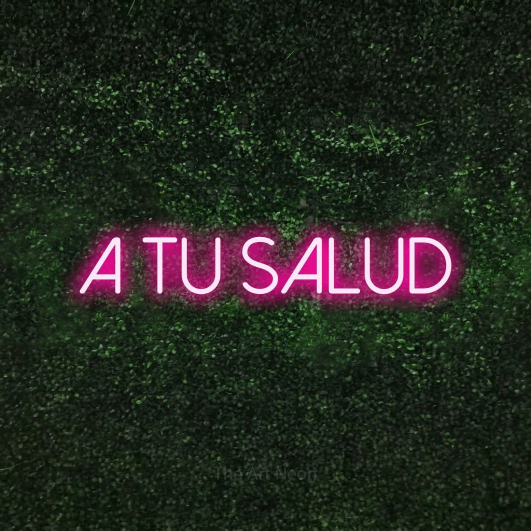 LED neon sign reading “a tu salud”, arranged in a single line.